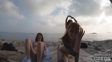 Three Gorgeous Girls Doing Naked Yoga On Rocky Beach At Sunset