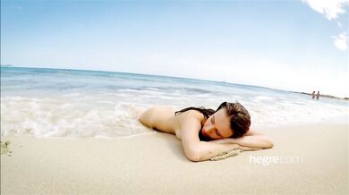 Teen brunette naked on a public beach