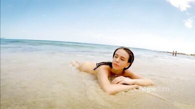 Teen brunette naked on a public beach