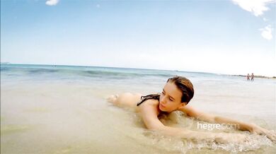 Teen brunette naked on a public beach