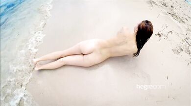 Teen brunette naked on a public beach